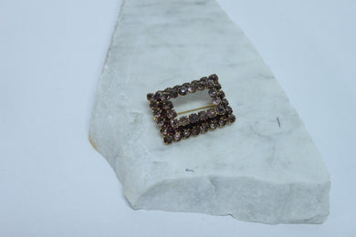 Broche rectangulaire dorées sertie de pierres mauves